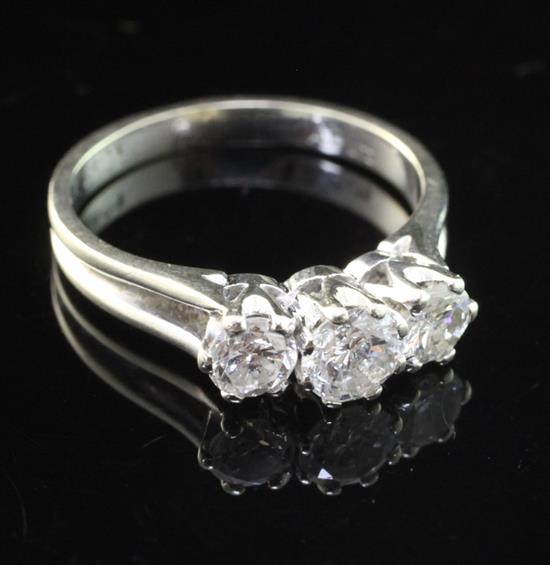 A modern 18ct white gold and three stone diamond ring, size N.